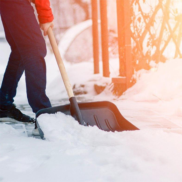 Лопата для уборки снега во дворе дома - фото